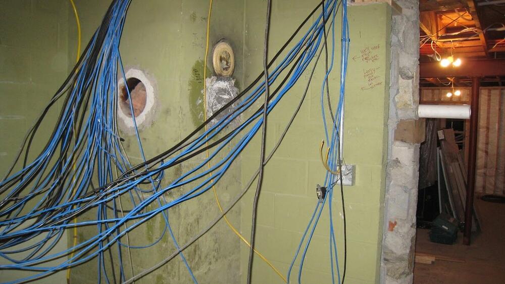 Before photo of cluttered network cabling prior to professional installation
