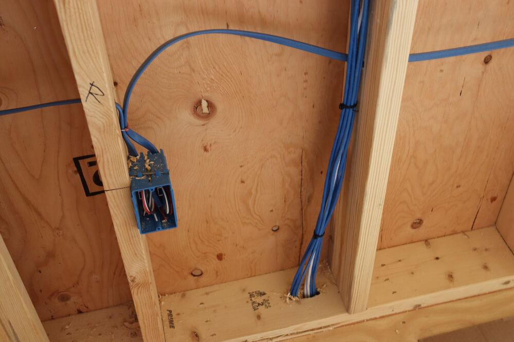 Network cable rough-in with blue low-voltage box in wall framing