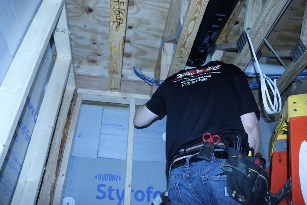 Netwire PC technician running network cables through framing